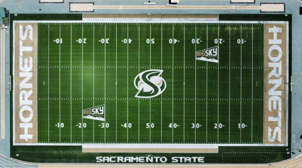 Athletic director on a Sprinturf football field at sunset